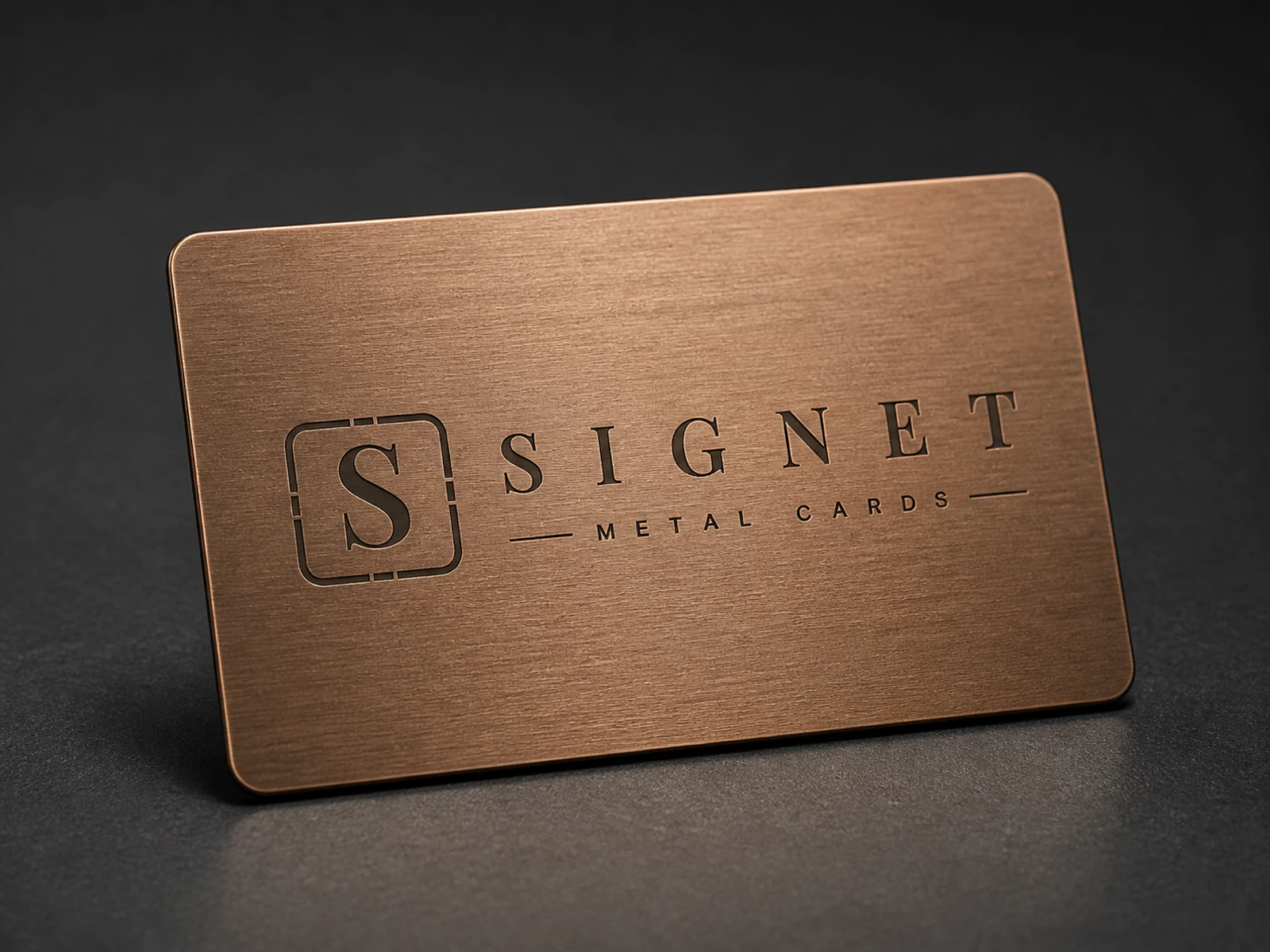 Warm brushed copper Signet metal card on a dark studio surface.