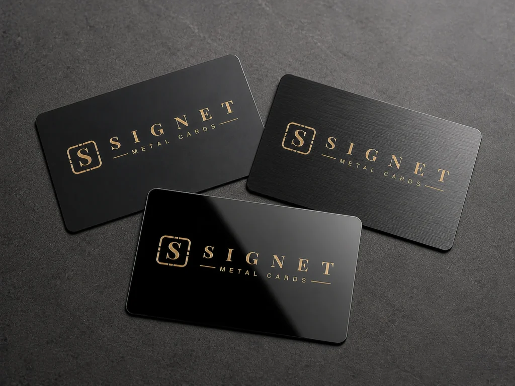 Matte, brushed, and mirror black stainless steel business cards arranged on a dark surface