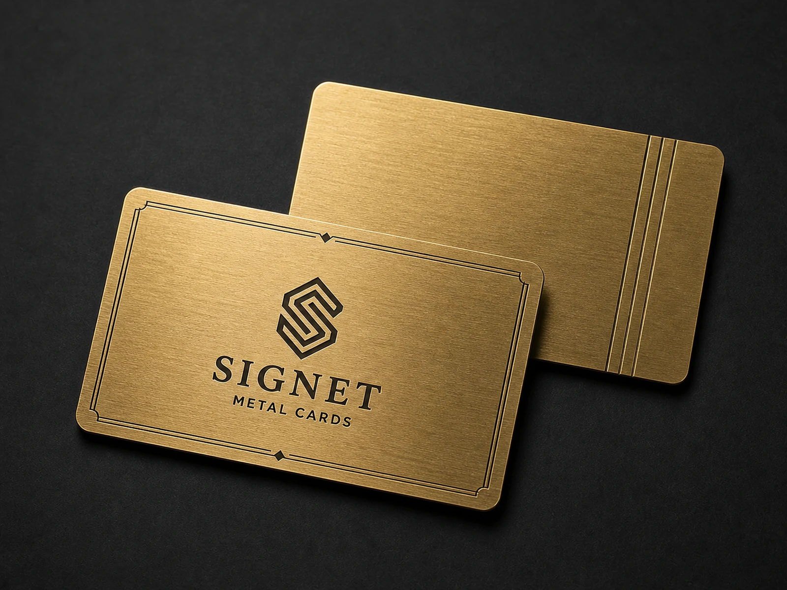 Two warm brass business cards with dark engraved details
