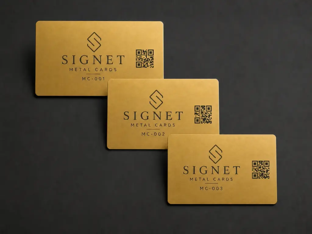 Three matte gold stainless steel business cards with QR codes and variable identifiers MC-001, MC-002, and MC-003