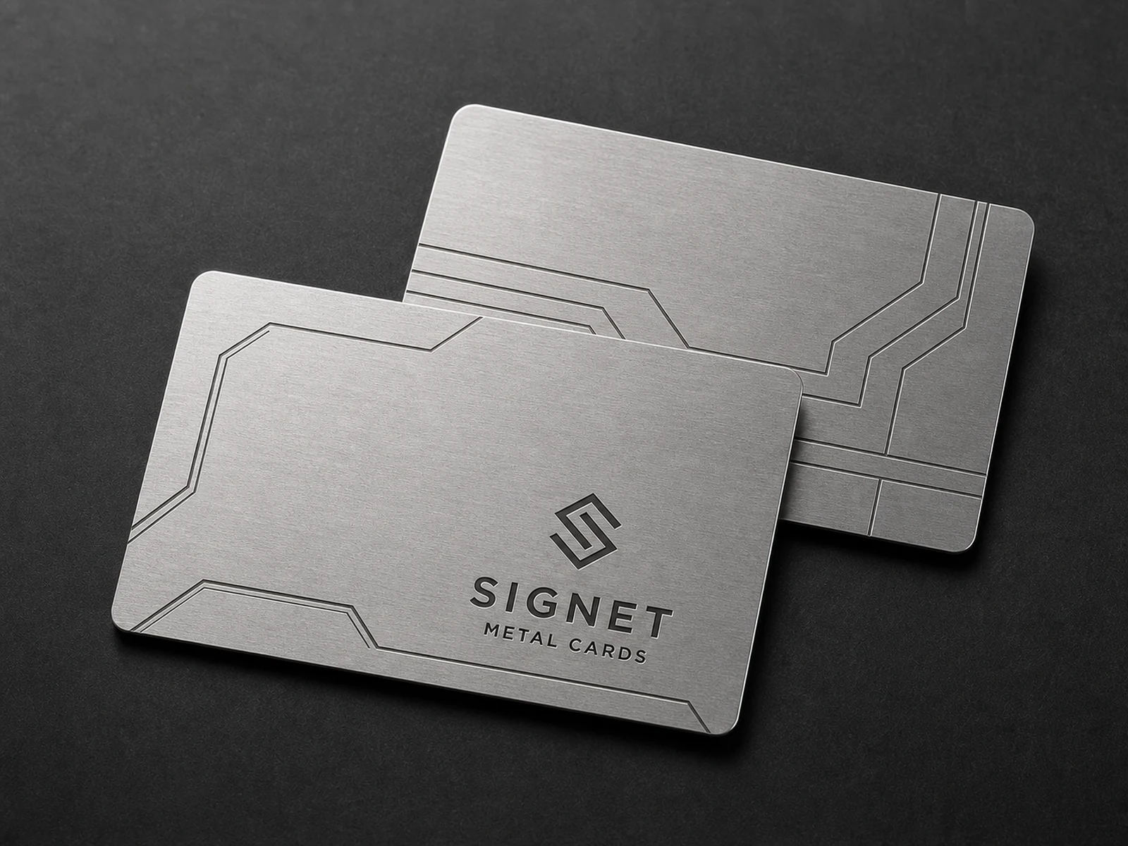 Two silver aluminum metal business cards with dark laser engraved linework